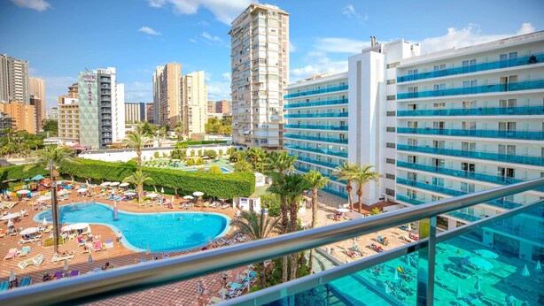 A hotel with a rooftop pool, multiple floors, and a cityscape in the background. - Hotel Servigroup Venus (Benidorm)