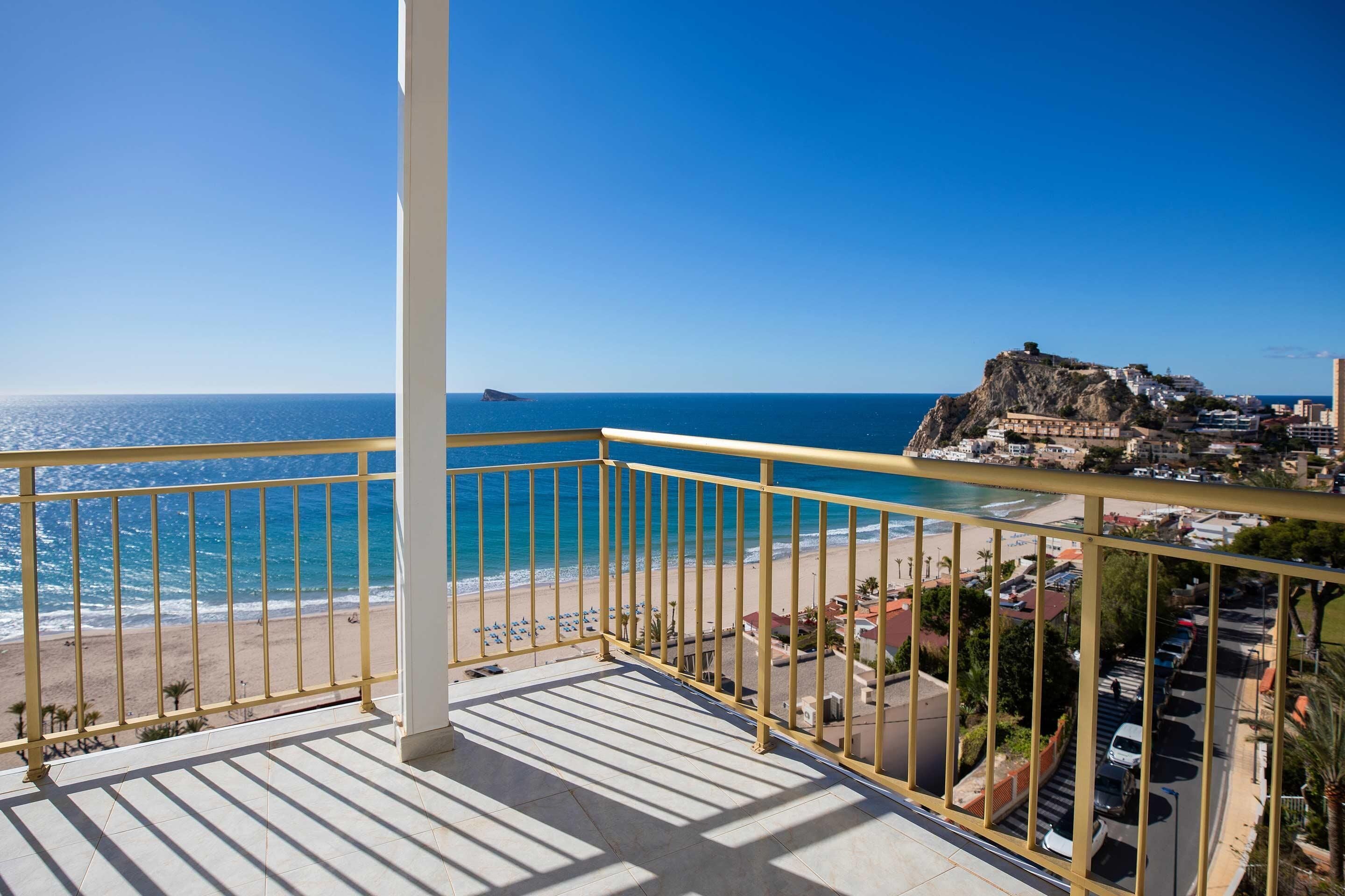 A balcony with a view of the beach and ocean.