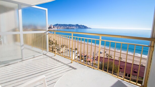 A balcony with a view of a beach and a distant cityscape. - Hotel Servigroup Torre Dorada (Benidorm)