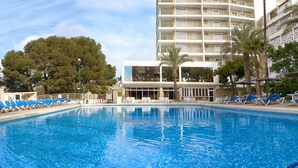 A swimming pool with lounge chairs and a building with balconies in the background. - Hotel Servigroup Torre Dorada (Benidorm)