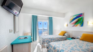 A hotel room with two beds, a desk, a TV, and a balcony with curtains. - Hotel Servigroup Torre Dorada (Benidorm)