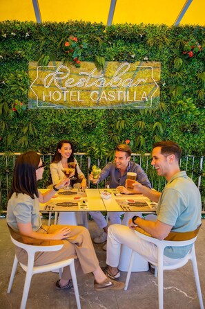 A group of people seated at a table with a sign reading 'Restabar HOTEL CASTILLA' in the background. - Hotel Servigroup Castilla (Benidorm)