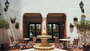 A courtyard with a fountain, outdoor seating, and potted plants. - Apartamentos Hesperia Bristol Playa (La Oliva)