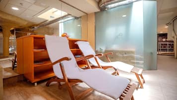Un área de spa moderna con tumbonas de madera y un mueble de madera con estantes.