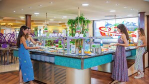 A buffet area with a central serving counter, surrounded by seating. - Hotel Servigroup Rialto (Benidorm)