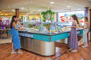 A buffet area with a central serving counter, surrounded by seating. - Hotel Servigroup Rialto (Benidorm)