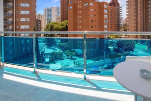 A modern apartment with a balcony overlooking a pool and a cityscape. - Hotel Servigroup Rialto (Benidorm)