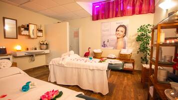 Relax in a serene spa room with a massage table, reception area, and calming decor.