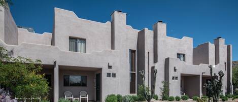 A modern house with a unique architectural style, featuring multiple entry points and a well-maintained garden with various cacti.