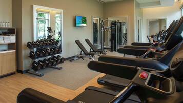 Ein Fitnessstudio mit Laufbändern, Kurzhanteln und Krafttrainingsgeräten.
