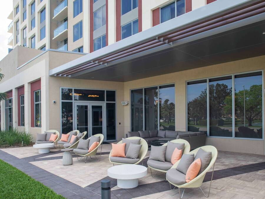 L’extérieur d’un hôtel, avec des espaces de repos en plein air, de grandes fenêtres et un design moderne.