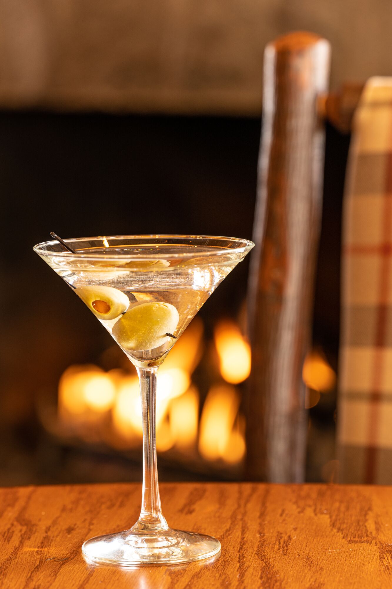 Una copa de martini con una rodaja de limón sobre una mesa de madera.