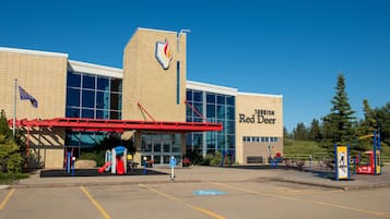 A building with a sign reading 'Tourism Red Deer' and a playground with a red slide.