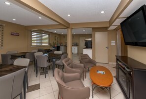 Une chambre d’hôtel avec un coin repas, une télévision et une kitchenette.
