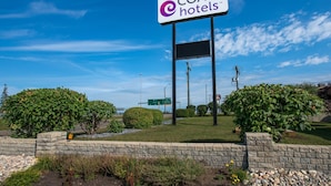 A sign for COAST hotels with a clear sky in the background.