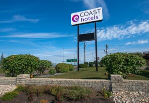 Une enseigne pour les hôtels COAST, avec un ciel dégagé en arrière-plan.