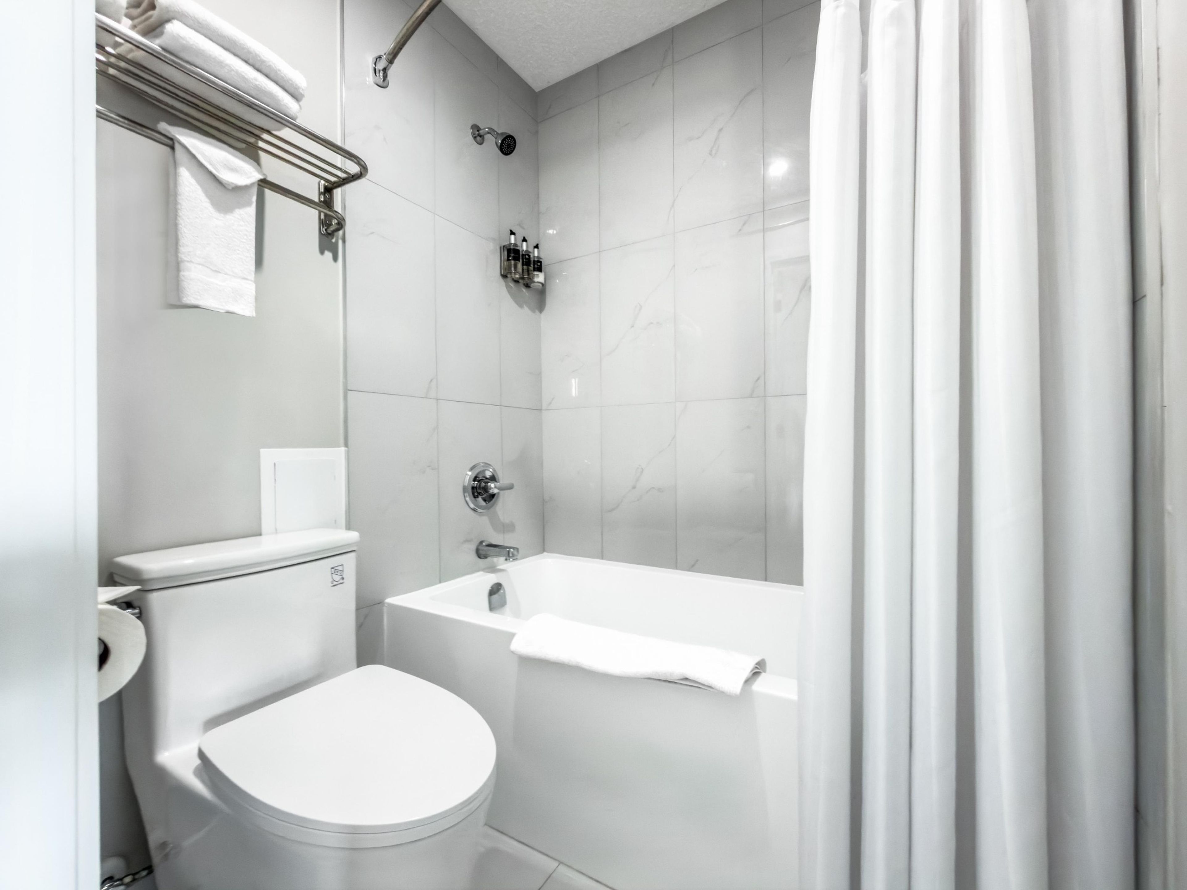 Un bagno moderno con un water, una doccia e una vasca da bagno.