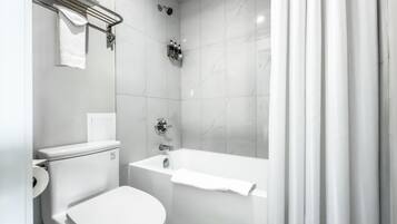 Un bagno moderno con un water, una doccia e una vasca da bagno.