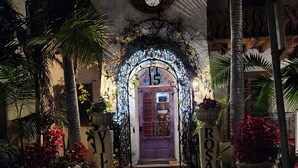 A well-lit entrance with a decorative archway, a purple door, and potted plants labeled 'VILLA' and 'ROSA'. - Ala Mar by the Sea (Santa Barbara)