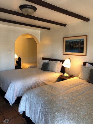 A hotel room with two beds, a painting on the wall, and a small table with a lamp. - Ala Mar by the Sea (Santa Barbara)