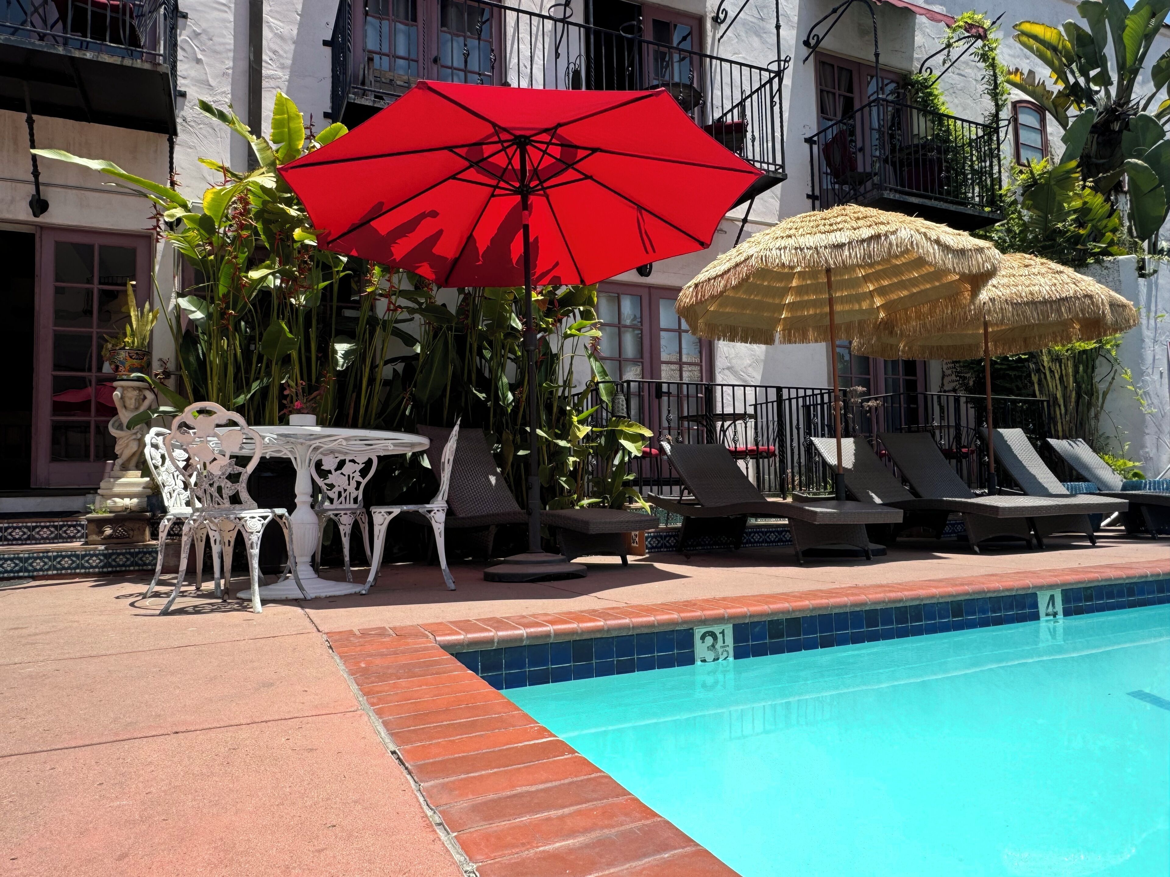 Una piscina al aire libre, sombrillas, tumbonas