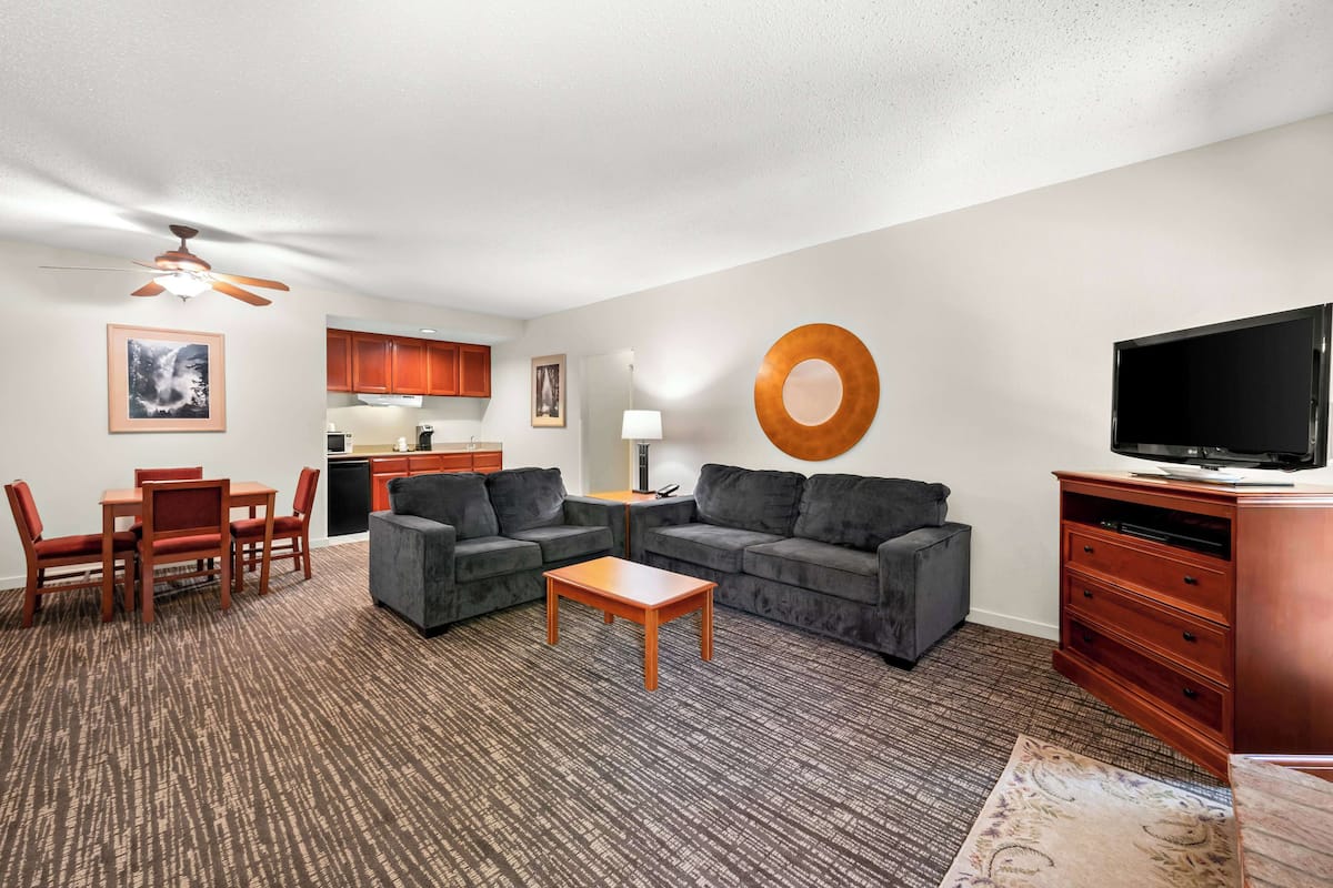 A living room with a sofa set, a coffee table, a TV, and a fireplace.