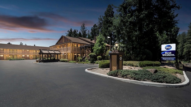 A hotel entrance with a covered walkway, a sign for Best Western Stagecoach Inn, and a parking lot.