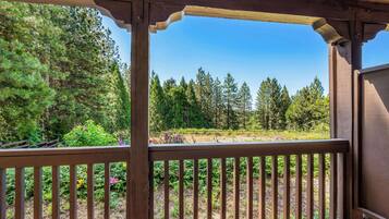 A wooden deck with a view of a forested area.