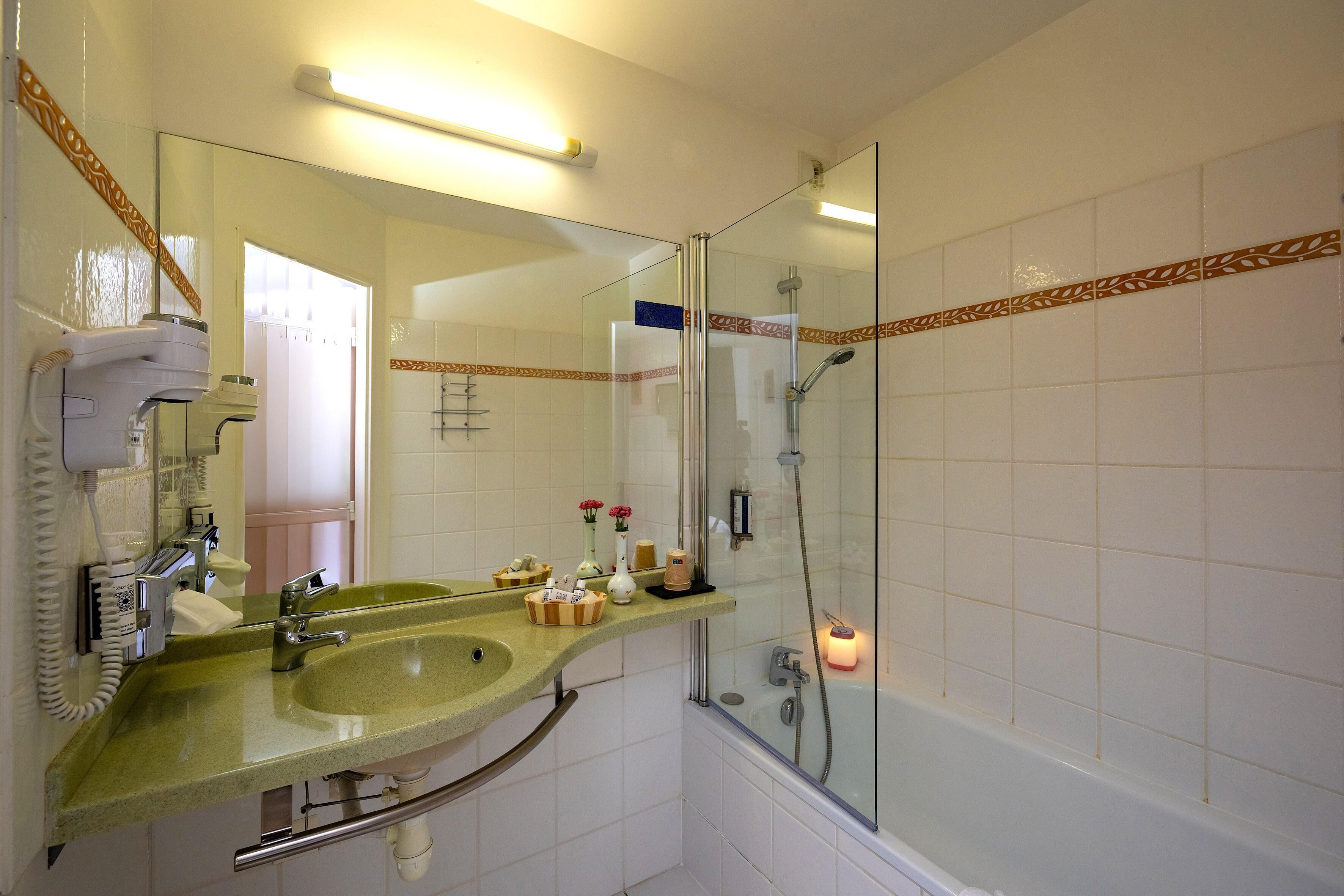 Un baño con lavamanos, espejo, ducha e inodoro.