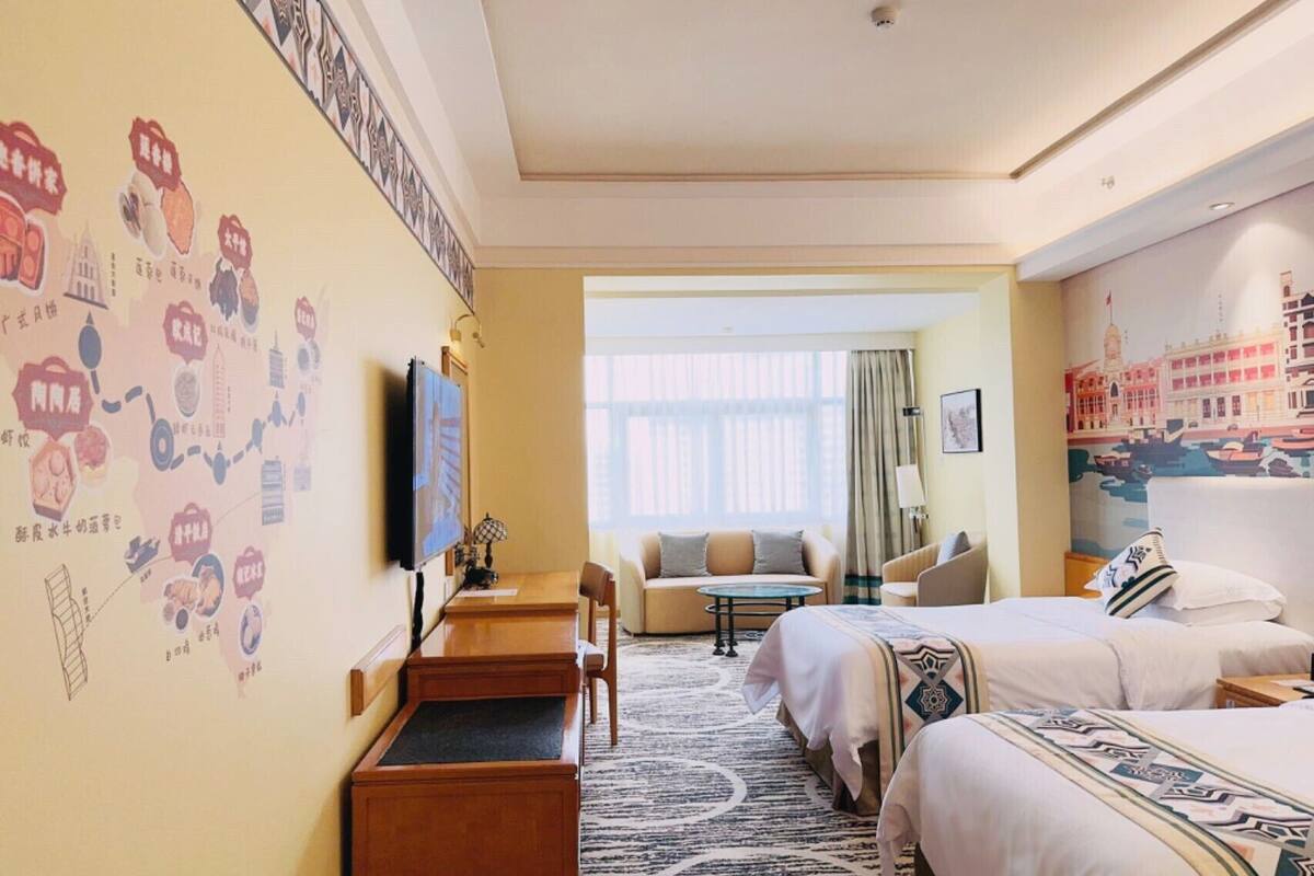 Une chambre d’hôtel avec un lit, un bureau, une chaise, une télévision et une fenêtre.