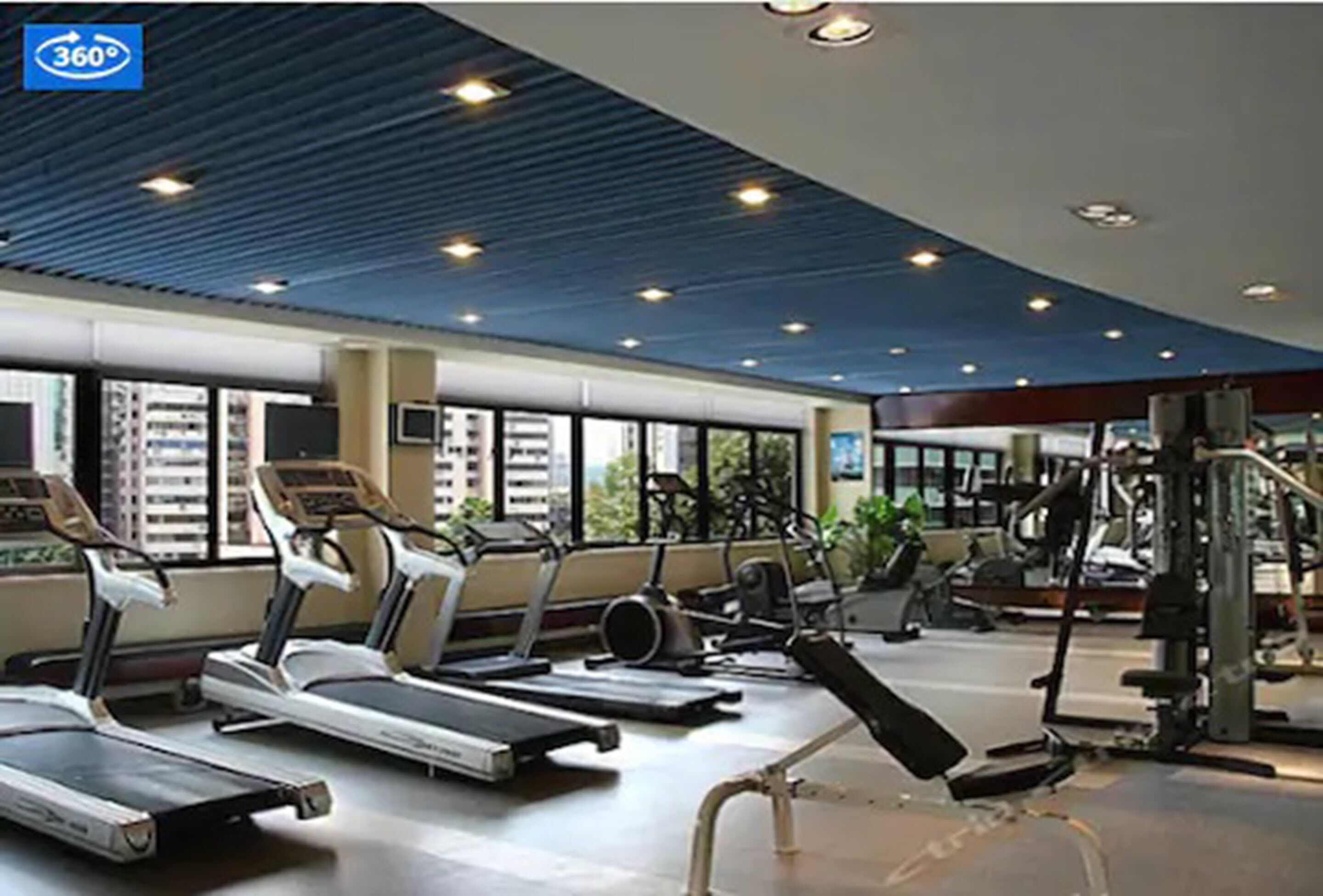 Un gimnasio con cintas de correr, bicicletas estáticas y máquinas de pesas.