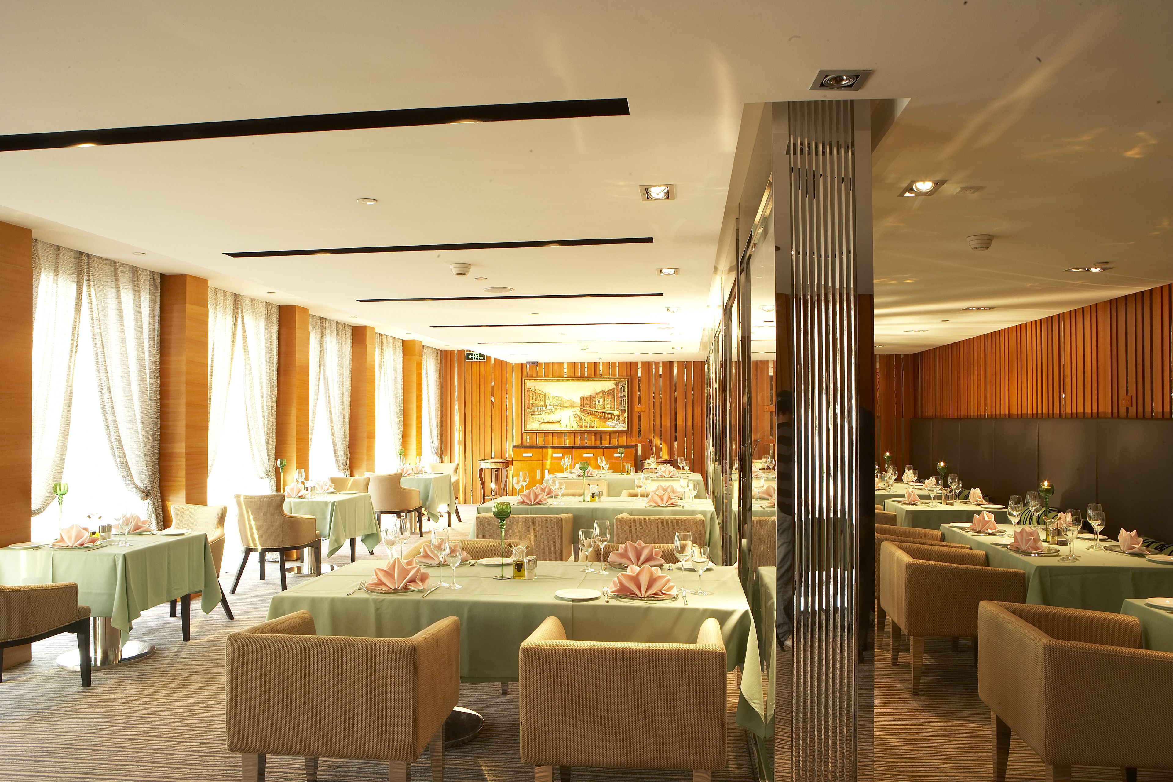 Un restaurante con varias mesas y sillas, una pared de madera y un espejo grande.