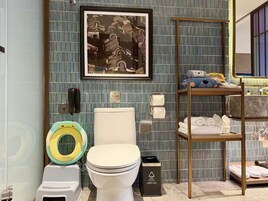 Un bagno con un WC, bidet e uno scaffale con asciugamani e articoli da toilette.