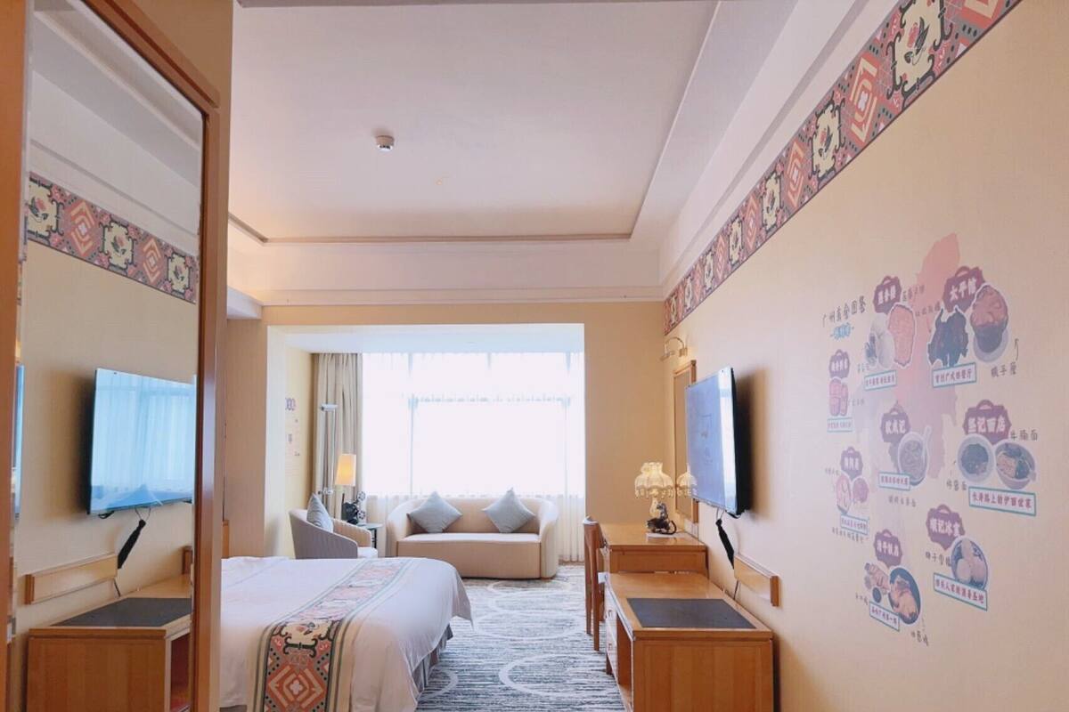 Une chambre d’hôtel équipée d’un lit, d’un bureau, d’une chaise, d’une télévision et d’un mur orné d’une carte.