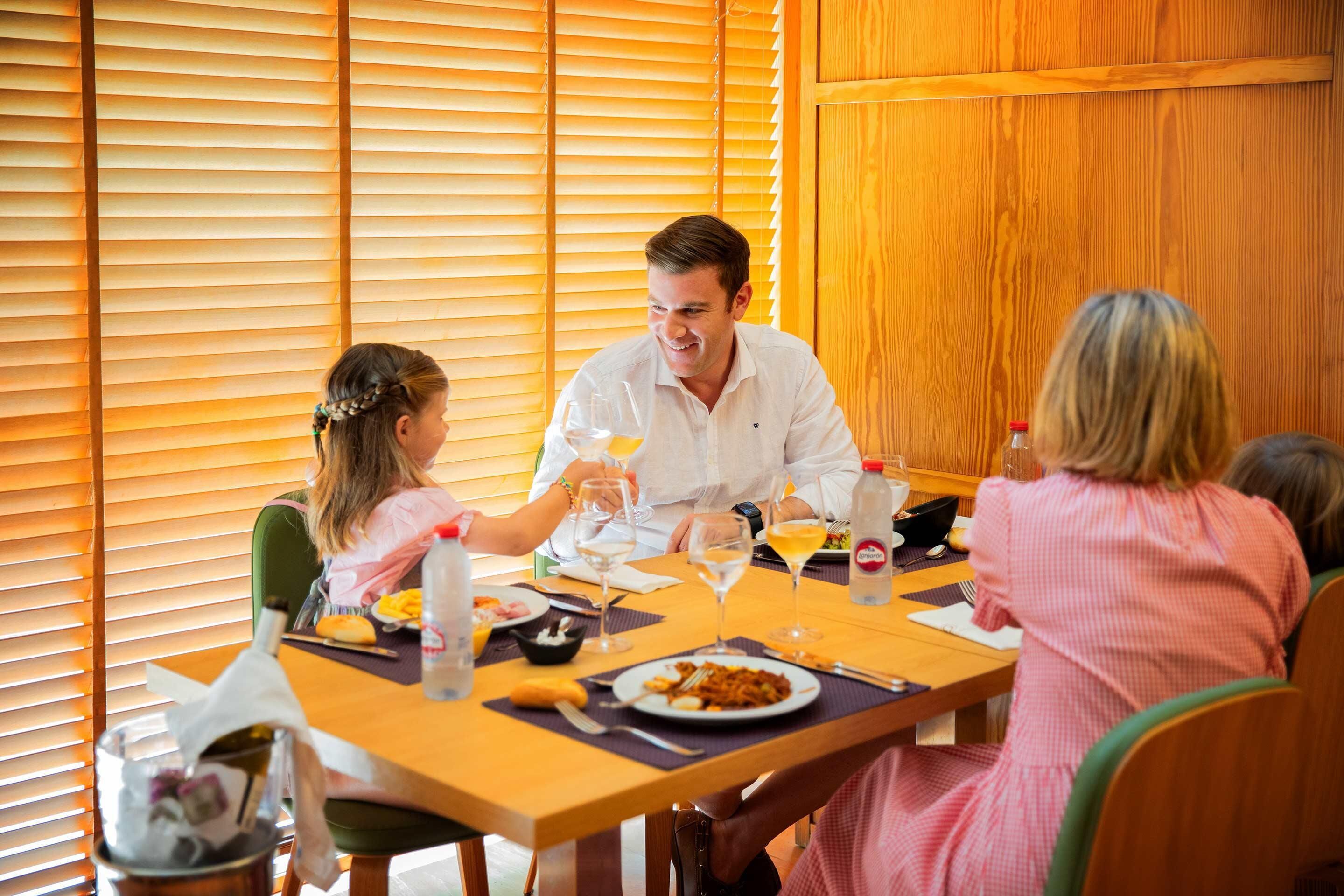 A dining table with plates, glasses, and a bottle.