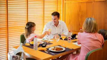 Una mesa de comedor con platos, vasos y una botella.