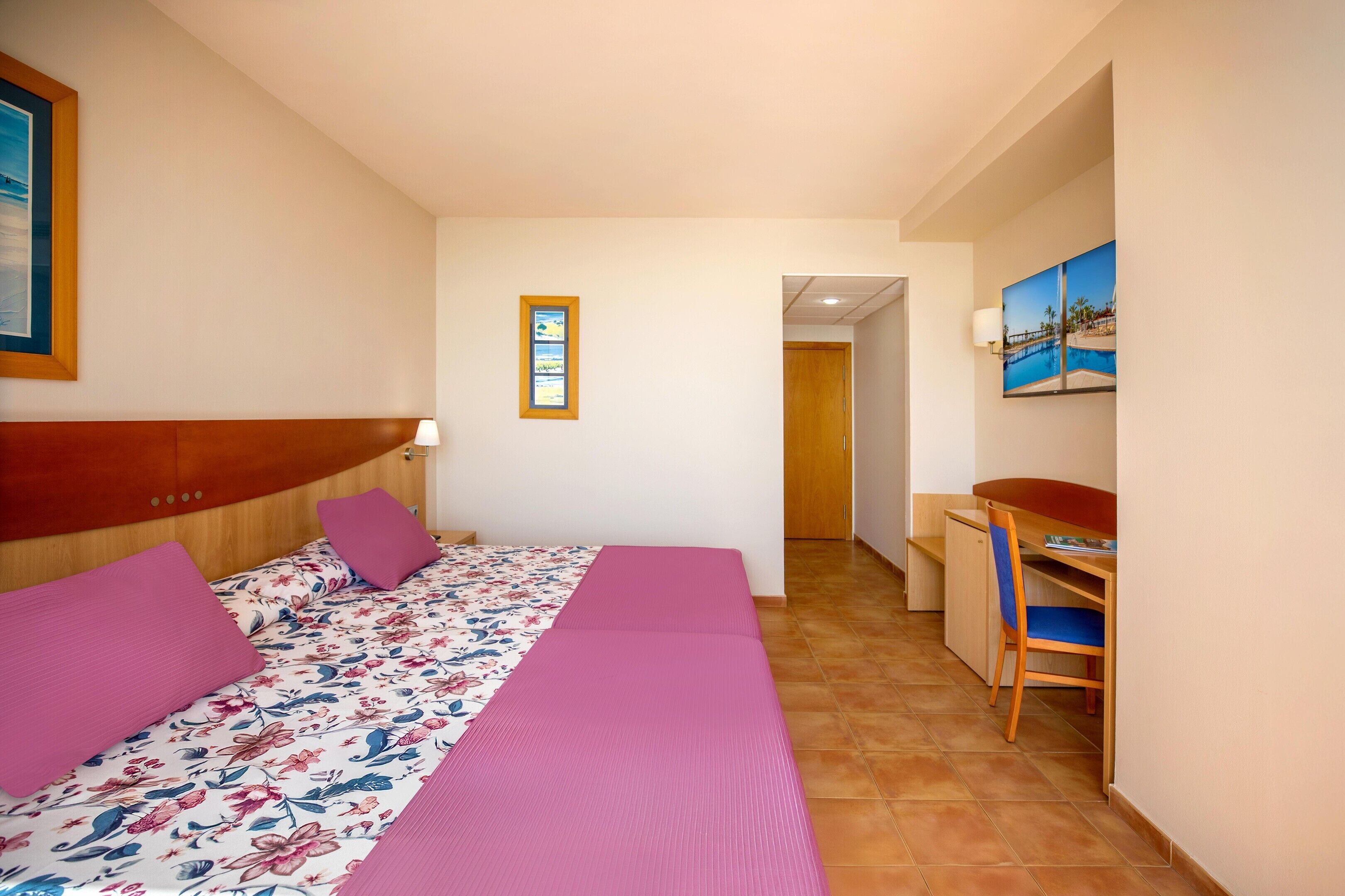 Un dormitorio con cama, escritorio y silla.