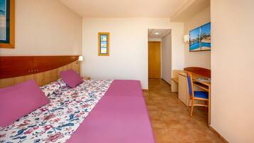 Un dormitorio con cama, escritorio y silla.