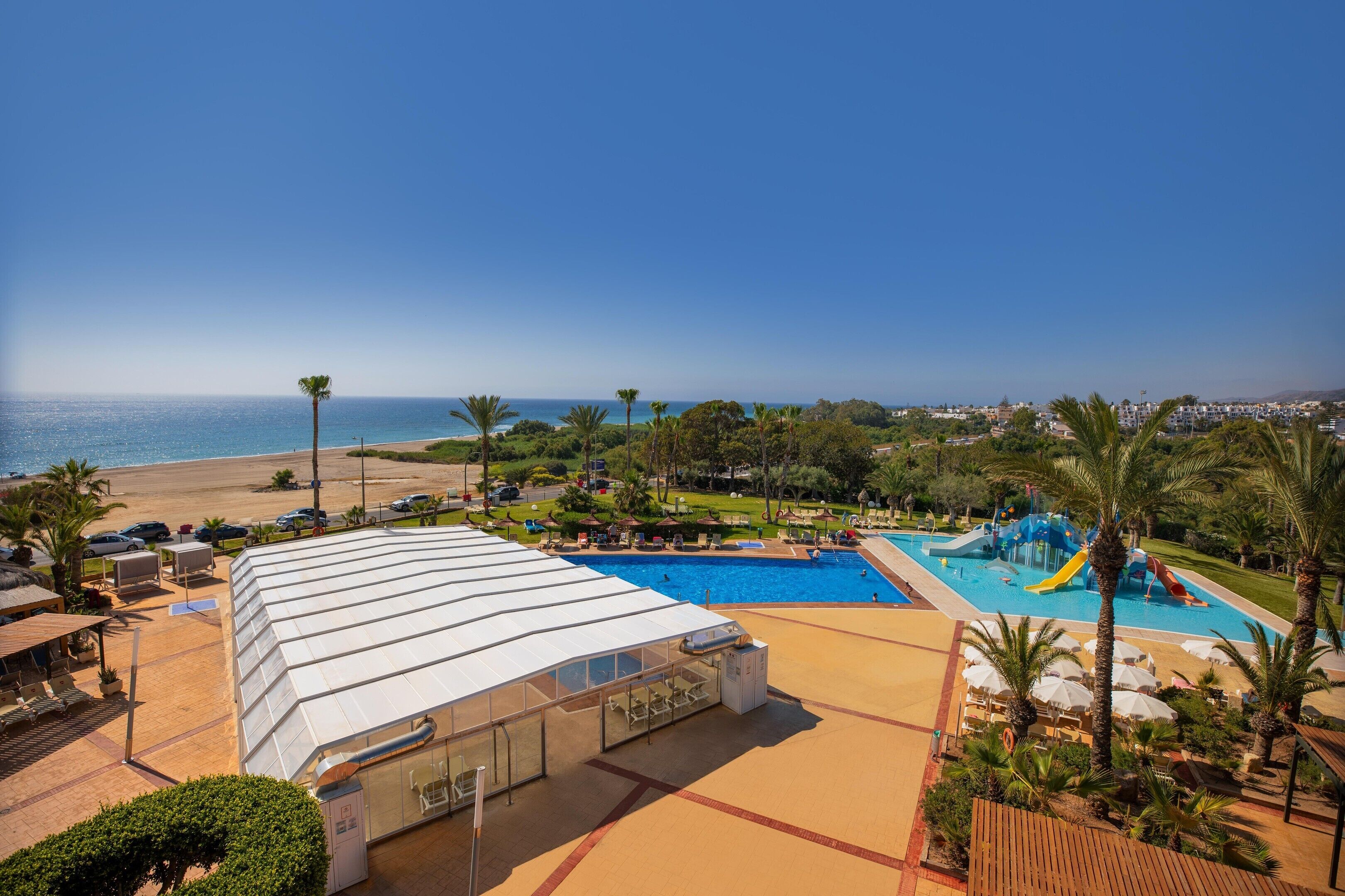 A resort with a pool, beach, and ocean view.