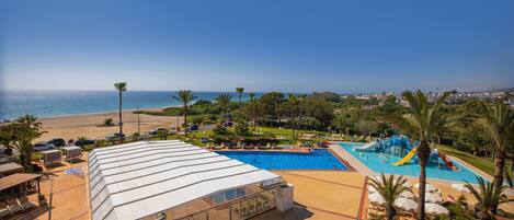 A resort with a pool, beach, and ocean view.