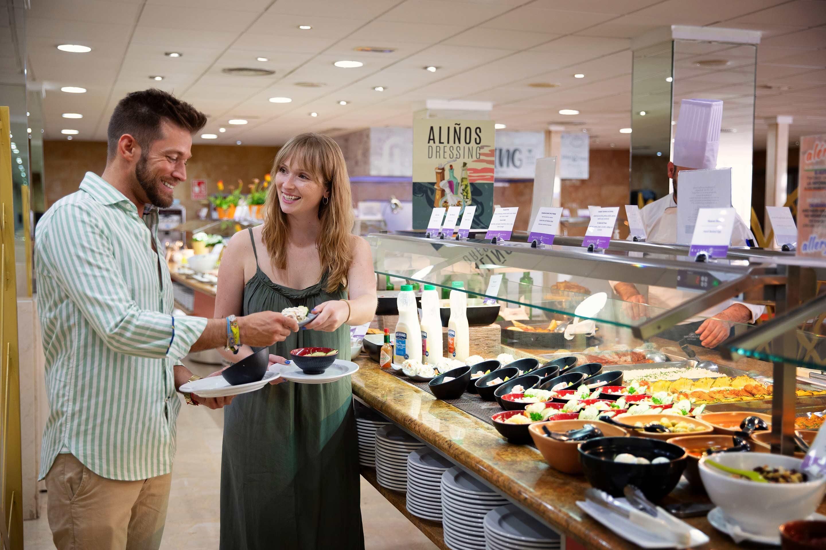 Un área de bufé con diversas opciones de comida y un letrero que dice 'ALINOS DRESSING'.