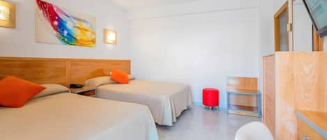 A hotel room with two beds, a TV, a wooden headboard, a colorful abstract painting, and a red stool.
