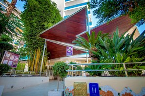 A hotel entrance with a covered walkway, a sign indicating no smoking, and a mosaic wall. - Hotel Servigroup Nereo (Benidorm)