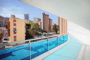 Ein Pool auf dem Dach mit Blick auf die Stadt, umgeben von Hochhäusern.