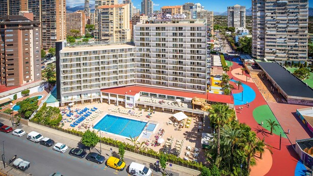 A hotel with a large pool area, multiple floors, and a parking lot. - Hotel Servigroup Orange (Benidorm)