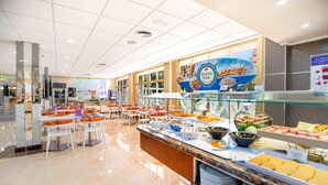 A modern breakfast buffet with a variety of food options, a clean and spacious layout, and a bright, well-lit environment.