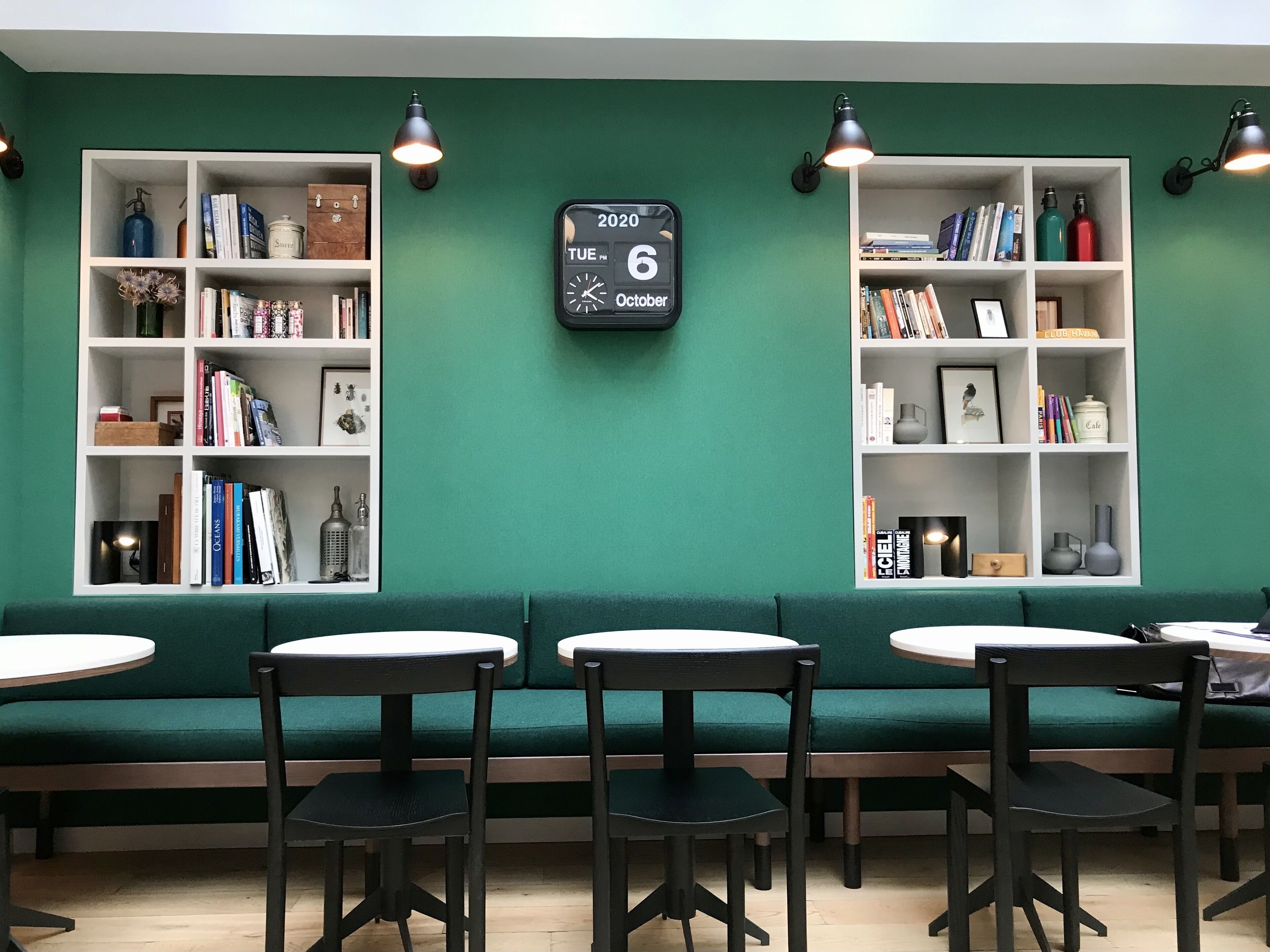 Una biblioteca con estanterías, un reloj y zonas de estar.