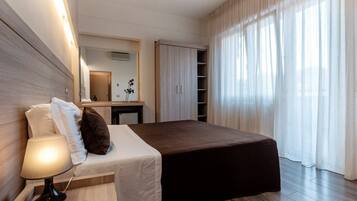 Ein Hotelzimmer mit einem Bett, einem Nachttisch, einer Lampe und einem Spiegel.