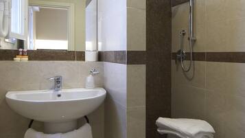 Une salle de bain avec un lavabo, un miroir et une douche.