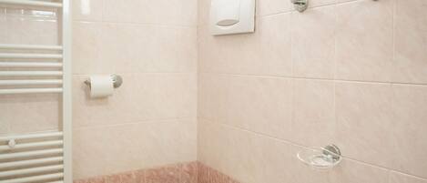 A bathroom with a toilet, bidet, and towel rack.